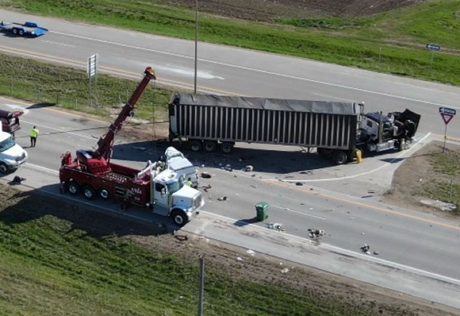Tow truck at an accident scene documenting vehicle positioning for forensic reconstruction and mechanical factor analysis