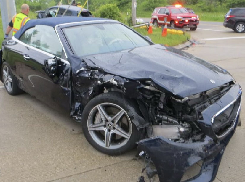 Front-end damage to a black sedan following a collision, used for forensic accident reconstruction analysis.